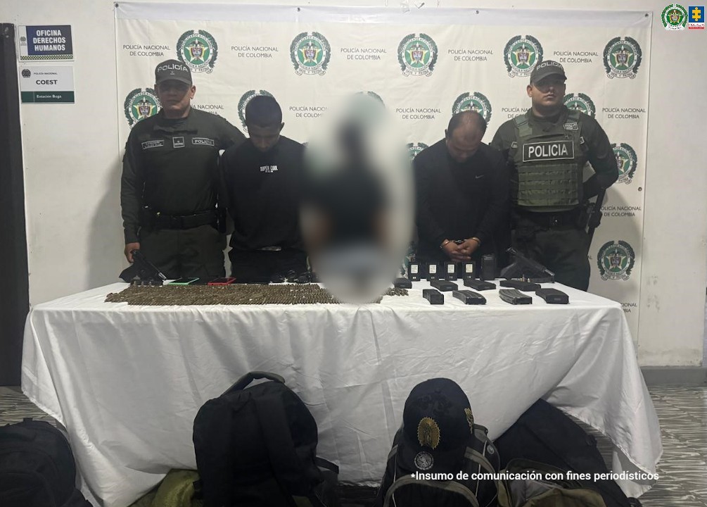 En la fotografía aparecen de pie, uno con los brazos atrás y otro con los brazos adelante y esposado Javier Andrés Ulcue Yonda, Yeison Stiven Giraldo Sinsajoa. Ambos visten con camisa de color negro. A sus extremos hay uniformados de la Policía Nacional. Delante de ellos hay una mesa y sobre ella se aprecian proveedores, gran cantidad de munición, radios de comunicaciones, celulares y cargadores. En el suelo hay varios morrales.