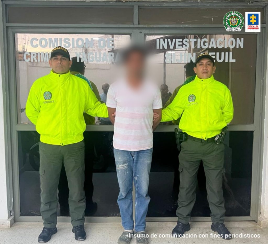 En la imagen se ve una persona detenida bajo custodia de dos integrantes de la Sijin de la Policía Nacional.