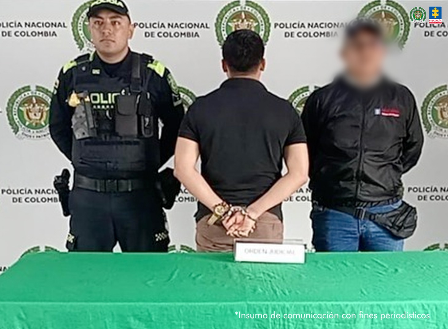 en la imagen se ve una persona detenida bajo custodia de un investigador del CTI y de la Policía.