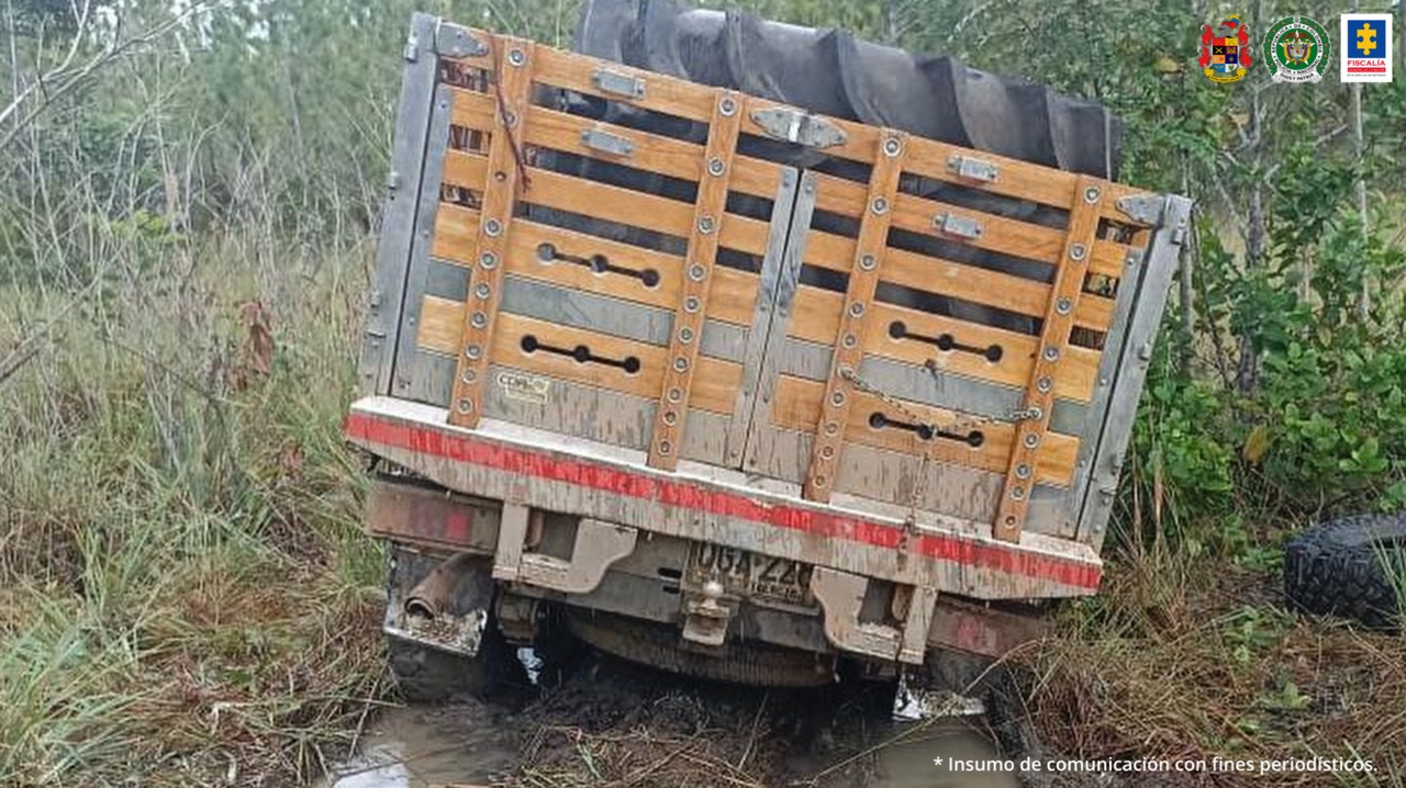 Un vehículo tipo camioneta está enterrada en el fango y en la carrocería están unas canecas donde se encontró el cargamento de cocaína.