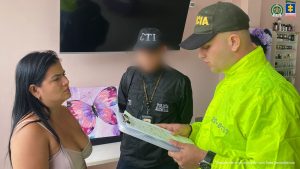en la imagen se ve una mujer a quien le están leyendo sus derechos un uniformado de la Policía Nacional y un investigador del CTI.