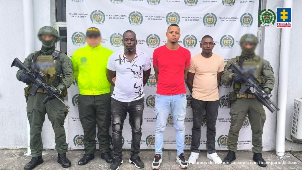 En la imagen se ve a tres hombres capturados junto a uniformados de la Policía, identificados como Huber Micolta Riascos, Edinson Viveros Angulo y Kevin Javier Reyes Victoria, quienes serían los encargados de ocultar clorhidrato de cocaína en los contendores que salían con destino a España.