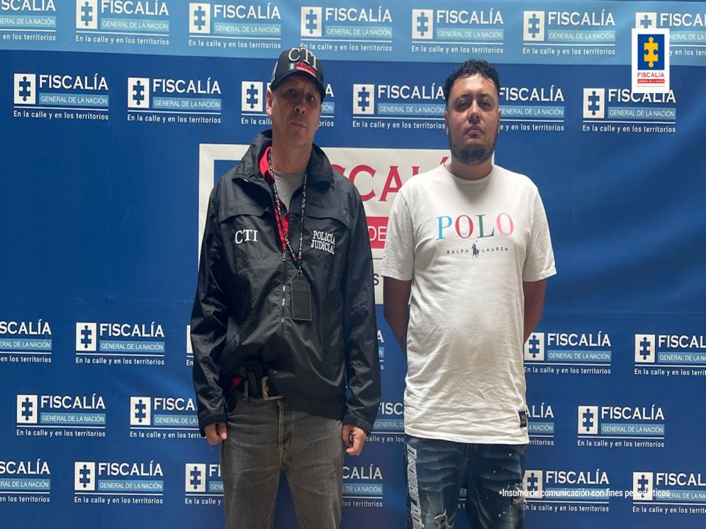 En la fotografía está el presunto agresor con un servidor del CTI y un pendón de la Fiscalía General de la Nación de color azul