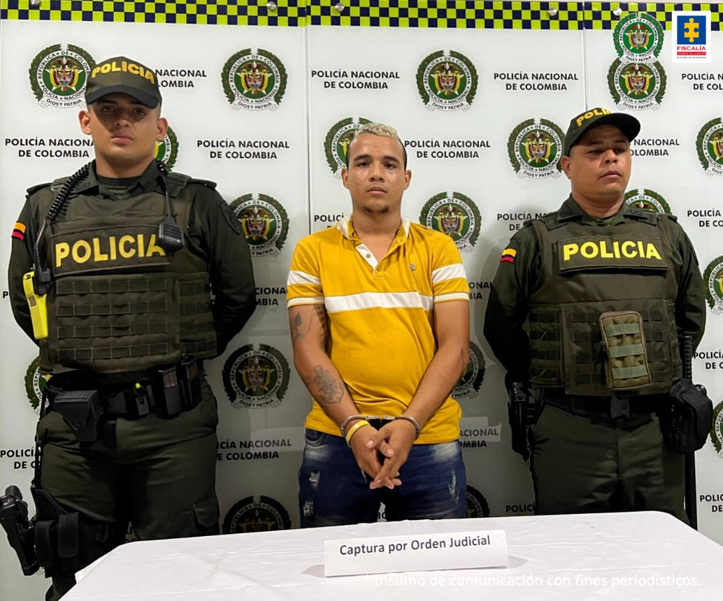 En la foto aparece el hoy asegurado custodiado por dos policías.