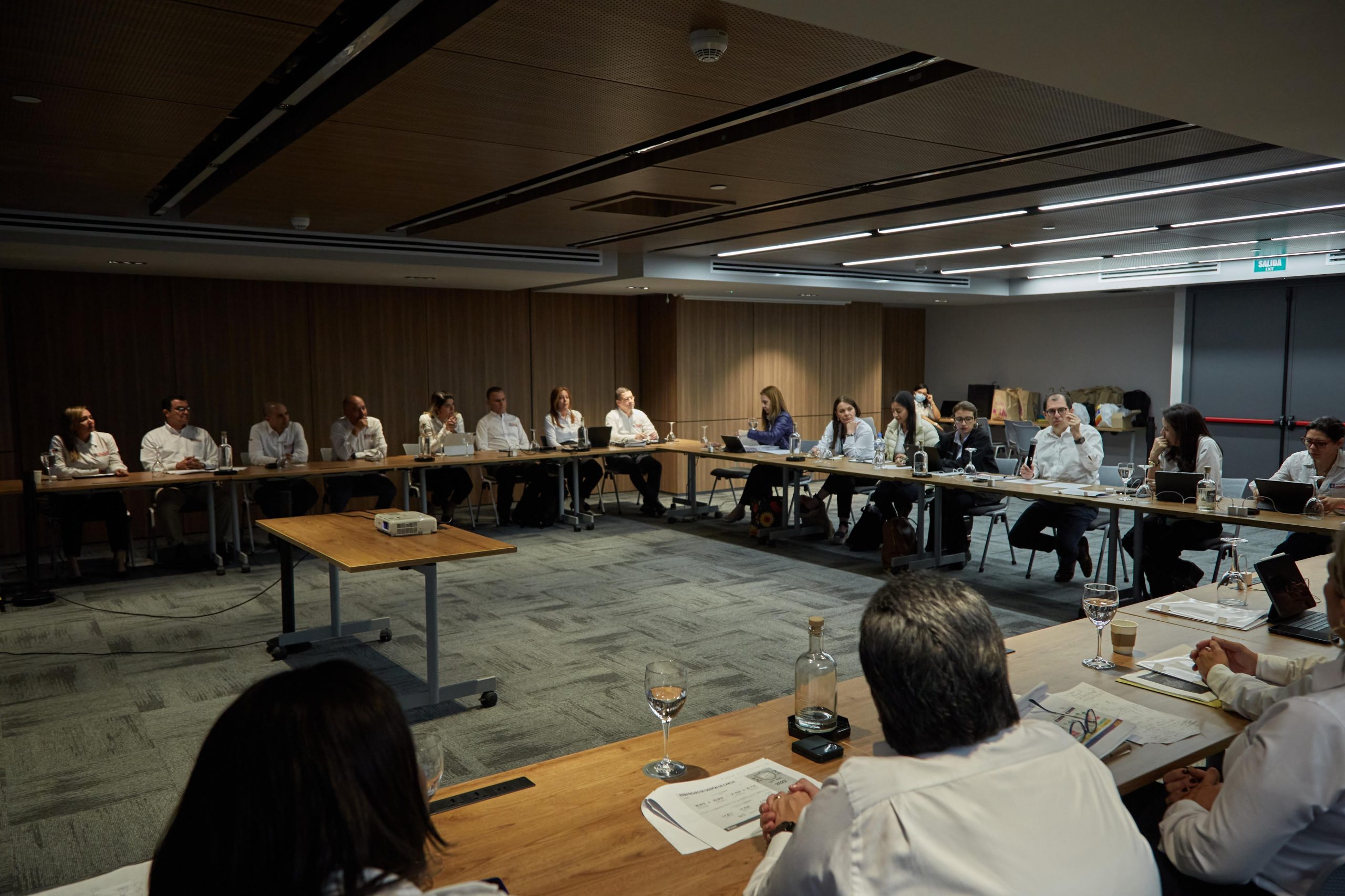 En la imagen aparecen cerca de 20 personas, reunidas en mesa redonda. 