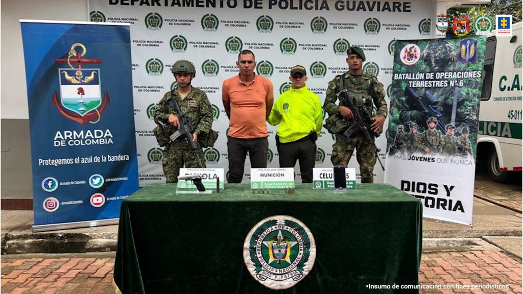 En la fotografía se observan cuatro personas, una de ellas el capturado, dos integrantes de la Armada Nacional y un uniformado de la Policía Nacional. En la parte posterior se observan backings de la Policía y la Armada.