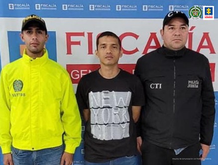 n la fotografía aparece un capturado, junto a personal de Policía Nacional y Fiscalía General de la Nación. En la parte posterior de la imagen se ven banners de Policía Nacional y la Fiscalía General de la Nación.  
