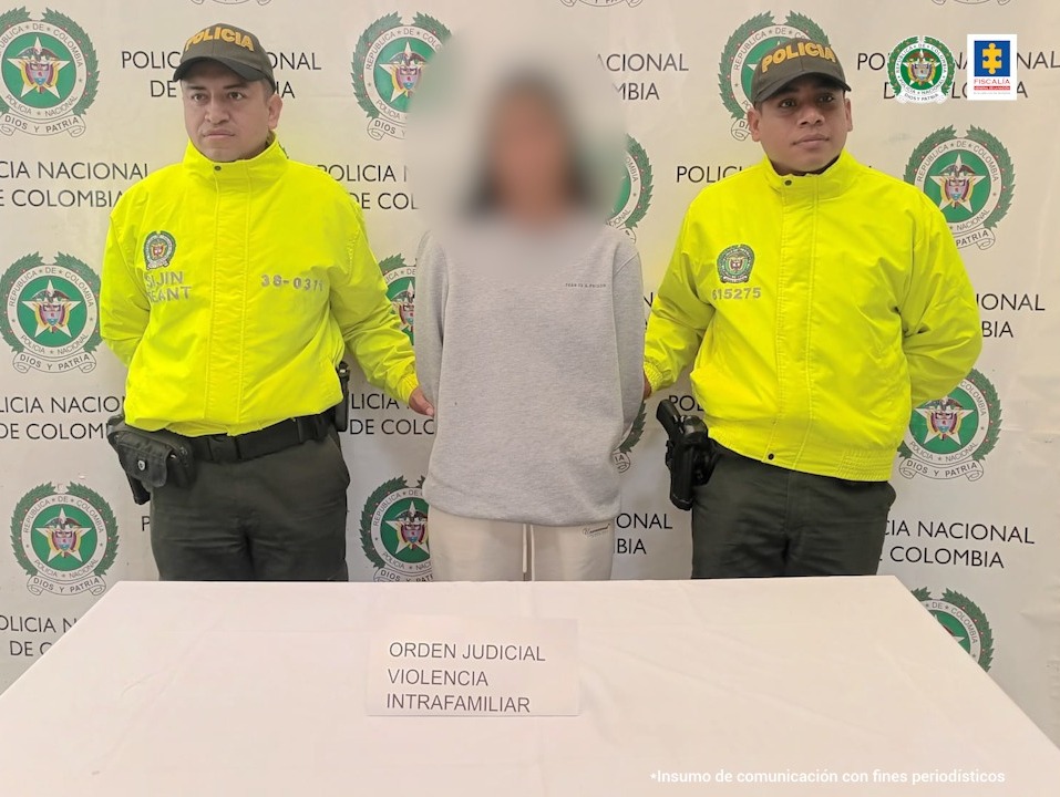 En la imagen está la mujer con el rostro distorsionado con dos servidores de la Policía Nacional a sus lados