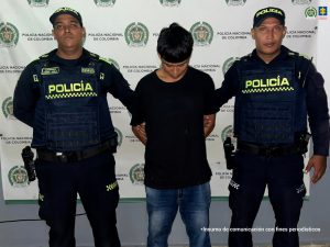 En la imagen se observa al procesado en compañía de dos uniformados de la Policía Nacional tras su captura mediante orden judicial.