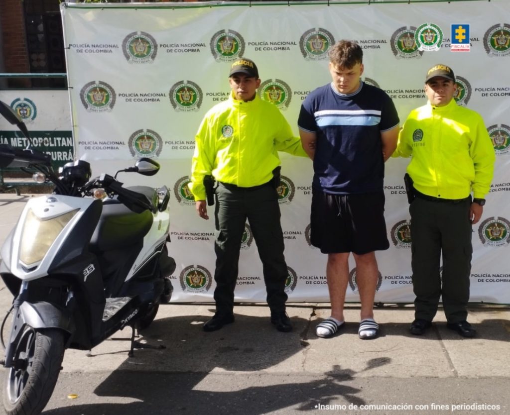 En la foto está el procesado por el  homicidio de un ingeniero en Medellín, con dos servidores de la Policía Nacional a los lados
