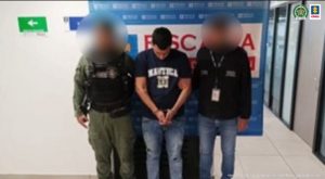 Fiscal Mancera, Fiscal Martha Mancera, Martha Mancera Se visualiza al capturado junto a un uniformado de la Policía Nacional y un investigador del CTI. Detrás de ellos el banner que identifica la Fiscalía General de la Nación.