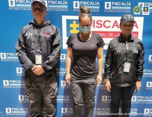 En la imagen está la suboficial de la policía con dos servidores del CTI a los lados y un pendón azul de la fiscalía en la parte de atrás