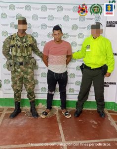 En la imagen aparece una persona capturada entre un soldado del Ejército y un policía.
