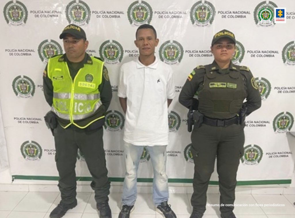 En la imagen se ve una persona capturada entre dos uniformados de la Policía Nacional. 