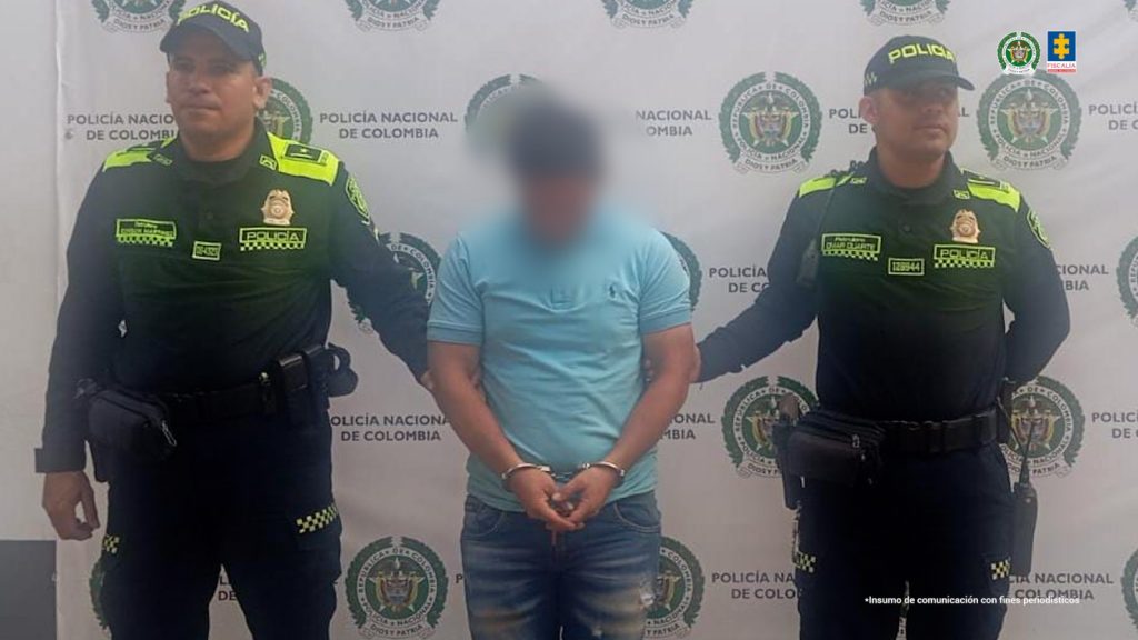 En la fotografía se observan tres personas, dos de ellas uniformados de la Policía Nacional y el capturado. 