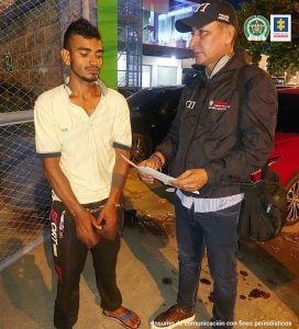 En la imagen se ve una persona con camiseta blanca junto con un investigador del CTI. 