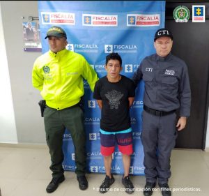 Se ve al detenido al lado de un policía de la Sijín y un agente del CTI de la Fiscalía General de la Nación