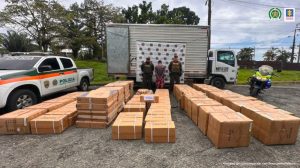 En la fotografía aparece el capturado junto dos agentes de la Policía Nacional. En la parte posterior, en el suelo, están las cajas de la carga hurtada