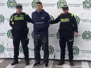 En la fotografía aparece el capturado junto a dos agentes de la Policía Nacional. En la parte superior está un banner de la Policía Nacional