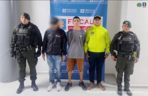 En la imagen se ve una persona detenida bajo custodia de investigadores del CTI y unidades de la Policía Nacional. Detrás suyo un backing institucional.
