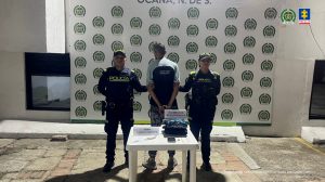 Se observa al capturado de espaldas junto a dos uniformados de la Policía Nacional. Frente a ellos los elementos hurtados y recuperados como celular, joyas, y el arma cortopunzante utilizada para el ilícito. En la parte posterior el banner que identifica a la Policía Nacional en Ocaña.